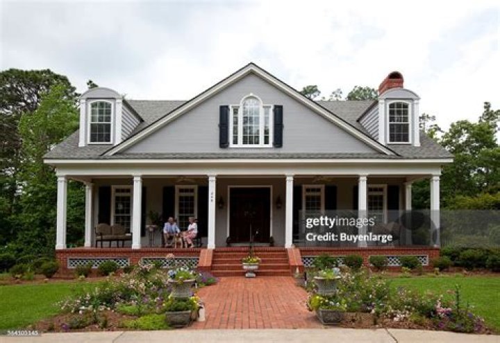 Billy Carson Bond and his wife Evelyn sitting on the porch with their dog, at home in