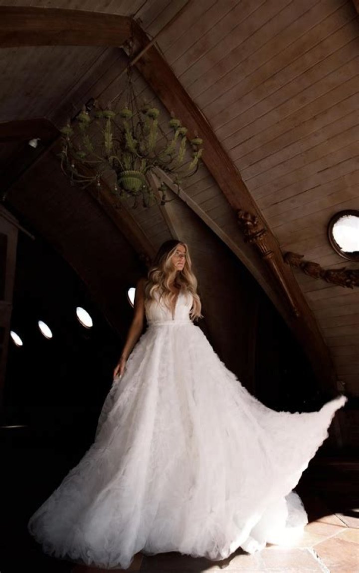 bride wears voluminous skirt and jumper next to groom
